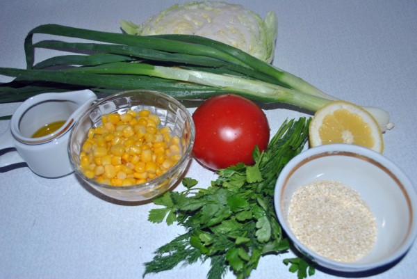 Ингредиенты для овощного салата из капусты, помидор, зеленого лука, кукурузы и семечек кунжута